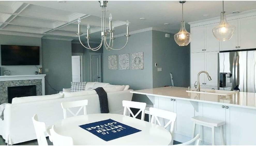 Esempio di una sala da pranzo aperta verso la cucina costiera di medie dimensioni con pareti blu, parquet scuro, camino classico, cornice del camino piastrellata e pavimento marrone