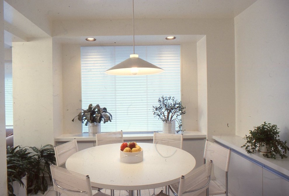 Cette image montre une petite salle à manger ouverte sur la cuisine minimaliste avec un sol en carrelage de céramique, un mur rouge et aucune cheminée.