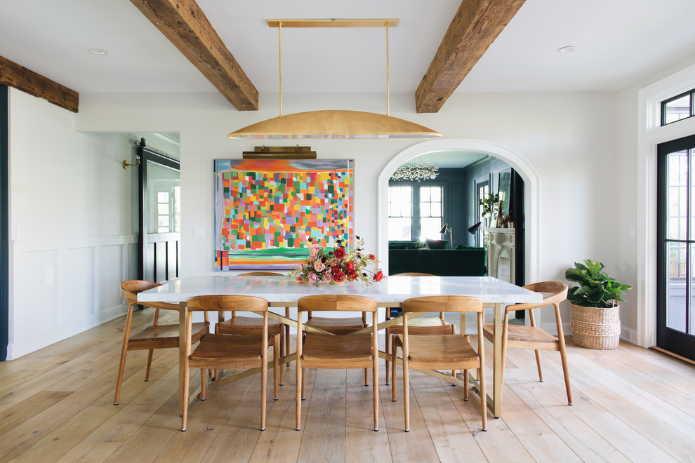 Idée de décoration pour une salle à manger ouverte sur la cuisine tradition de taille moyenne avec un mur blanc, un sol marron et parquet clair.