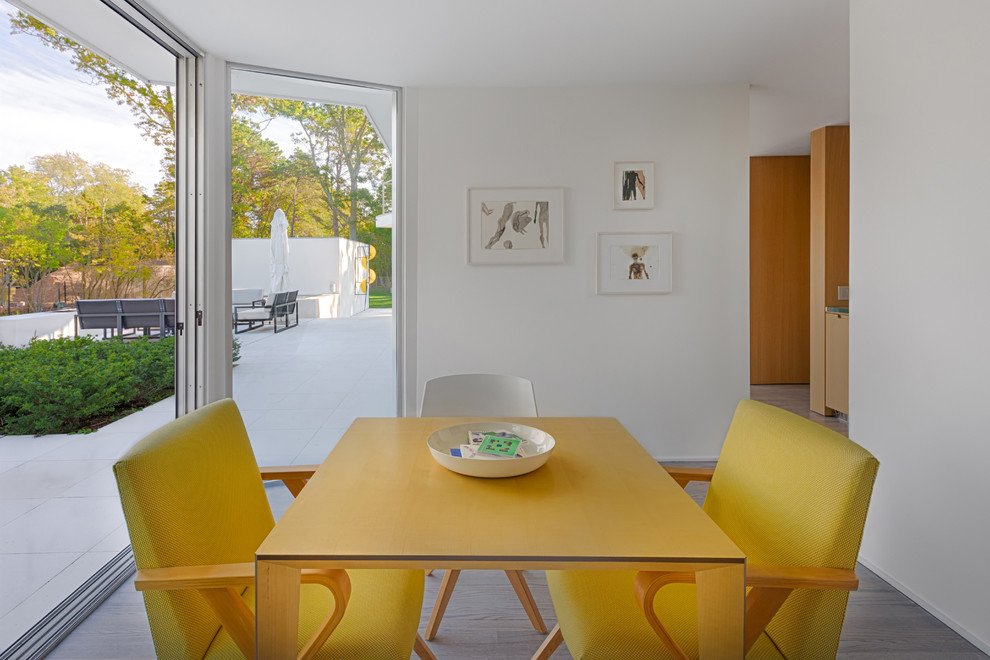 Пример оригинального дизайна: маленькая столовая в стиле модернизм с белыми стенами и светлым паркетным полом для на участке и в саду
