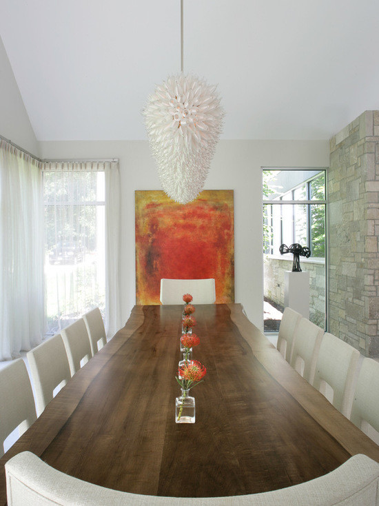 Réalisation d'une salle à manger ouverte sur le salon minimaliste de taille moyenne avec un mur blanc, un sol en marbre, une cheminée standard, un manteau de cheminée en béton et un sol gris.