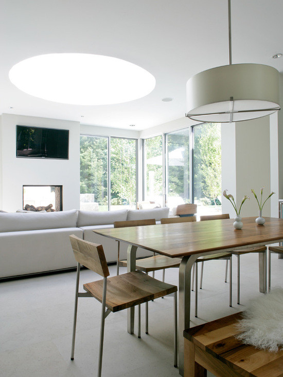 На фото: гостиная-столовая среднего размера в стиле модернизм с белыми стенами, мраморным полом, стандартным камином, фасадом камина из бетона и серым полом