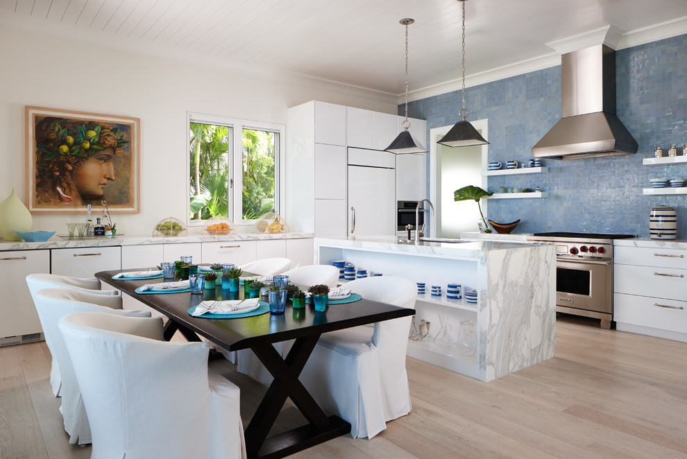 Immagine di una sala da pranzo aperta verso la cucina costiera di medie dimensioni con parquet chiaro e pareti beige