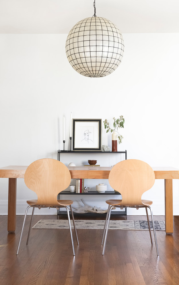 Diseño de comedor nórdico con paredes blancas, suelo de madera oscura y suelo marrón