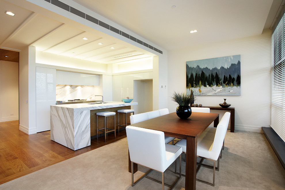 Foto di una sala da pranzo aperta verso il soggiorno design di medie dimensioni con pareti bianche, moquette, nessun camino e pavimento beige