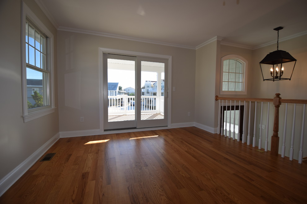 Idée de décoration pour une salle à manger ouverte sur le salon marine avec un mur blanc, un sol en bois brun et aucune cheminée.