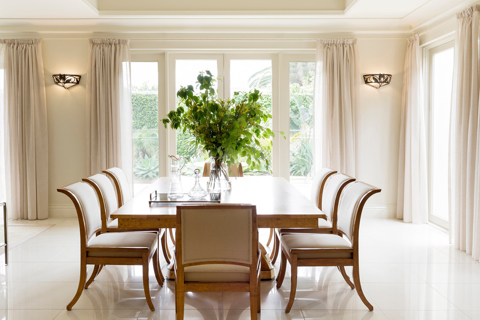 Immagine di una sala da pranzo aperta verso il soggiorno tradizionale con pareti beige