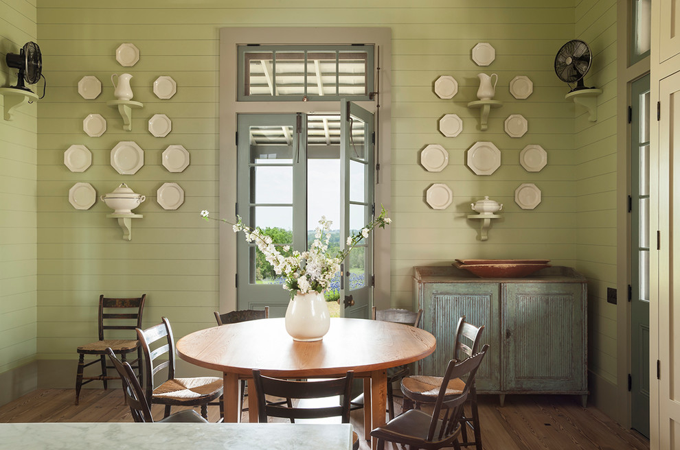 Imagen de comedor campestre con paredes verdes y suelo de madera en tonos medios