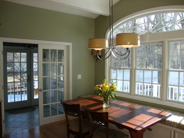 Foto di una sala da pranzo aperta verso la cucina tradizionale di medie dimensioni con pareti verdi, parquet scuro e pavimento marrone