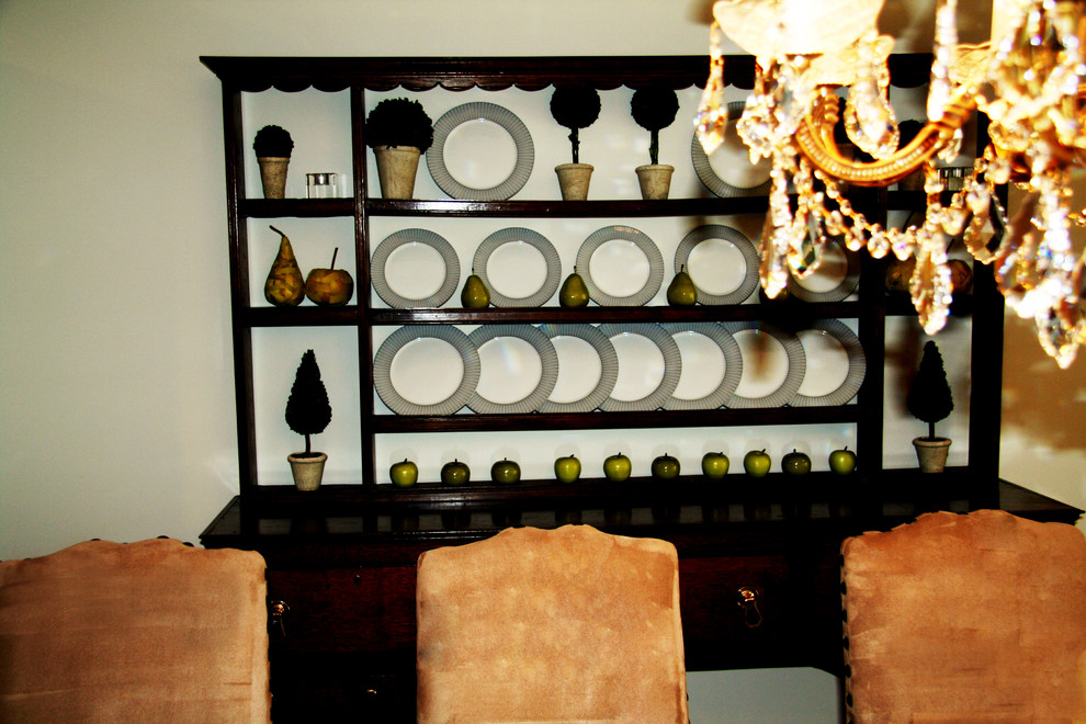 Cette image montre une grande salle à manger traditionnelle fermée avec un mur blanc et un sol en bois brun.
