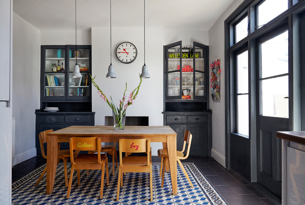 Esempio di una sala da pranzo aperta verso la cucina boho chic di medie dimensioni con pareti grigie, pavimento in gres porcellanato e camino classico
