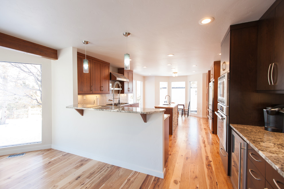 Mittelgroße Moderne Wohnküche mit weißer Wandfarbe, hellem Holzboden, Kamin, Kaminumrandung aus Stein und gelbem Boden in Omaha