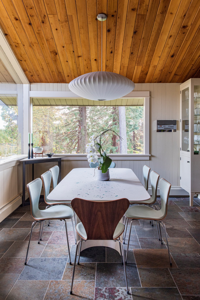 Foto di una grande sala da pranzo aperta verso la cucina minimalista con pavimento in ardesia, pavimento marrone, pareti beige, soffitto in legno e pareti in perlinato