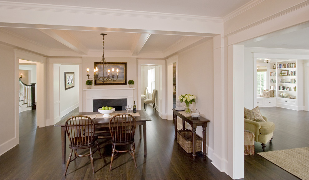 Photo of a large classic kitchen/dining room in New York with dark hardwood flooring, a standard fireplace, a stone fireplace surround, beige walls and brown floors.