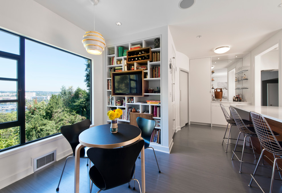 Cette image montre une salle à manger ouverte sur la cuisine design avec un mur blanc et parquet foncé.