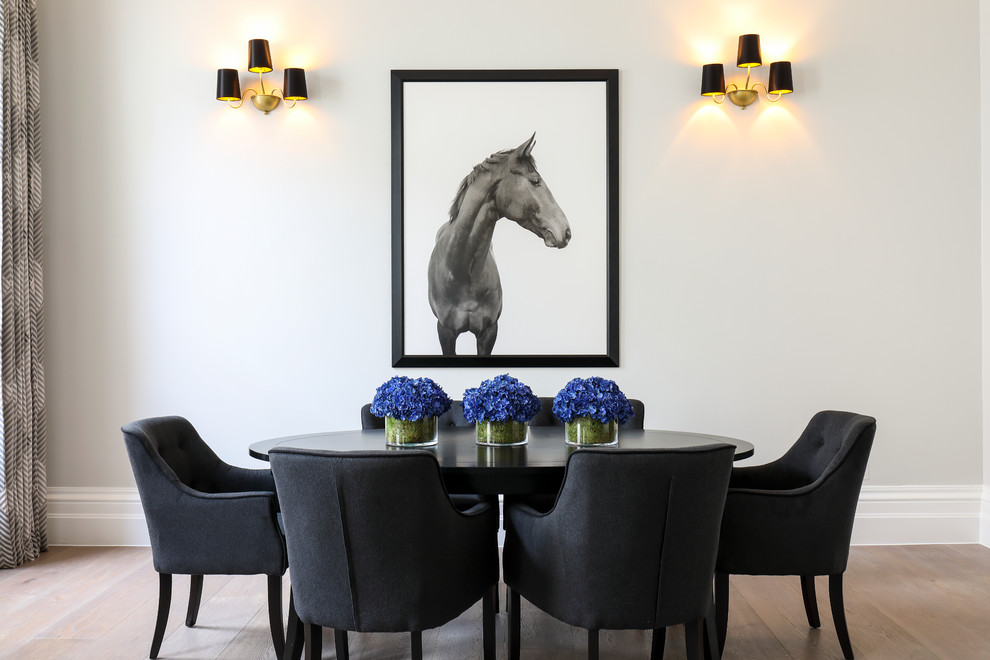 Eclectic dining room in London with grey walls and light hardwood flooring.