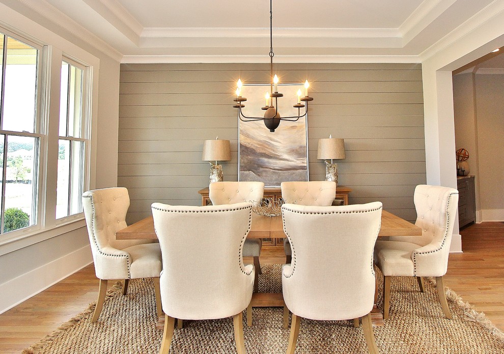 Aménagement d'une salle à manger classique avec un mur gris, un sol en bois brun, un sol marron et éclairage.