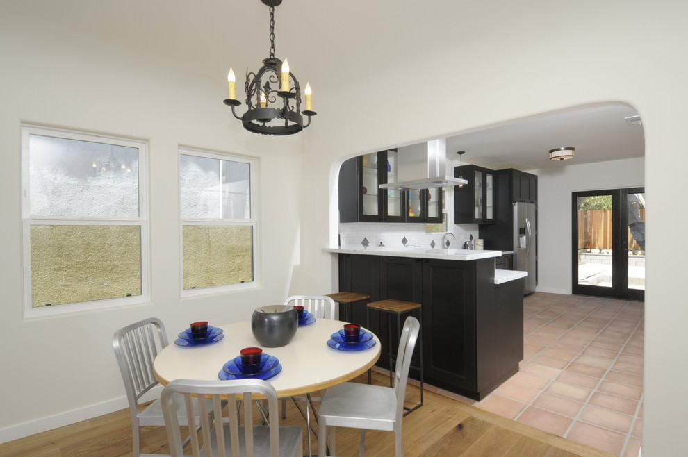 На фото: кухня-столовая среднего размера в средиземноморском стиле с белыми стенами и светлым паркетным полом с
