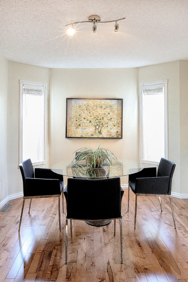 Immagine di una sala da pranzo aperta verso il soggiorno boho chic con pareti beige e pavimento in legno massello medio
