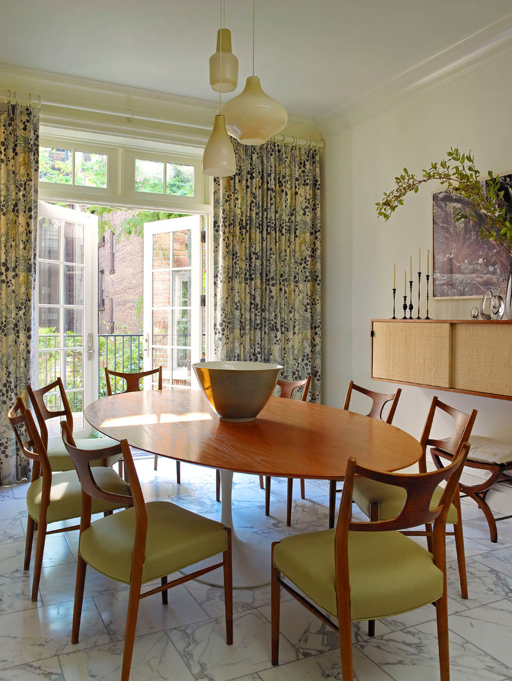 This is an example of an eclectic dining room in New York with white walls.