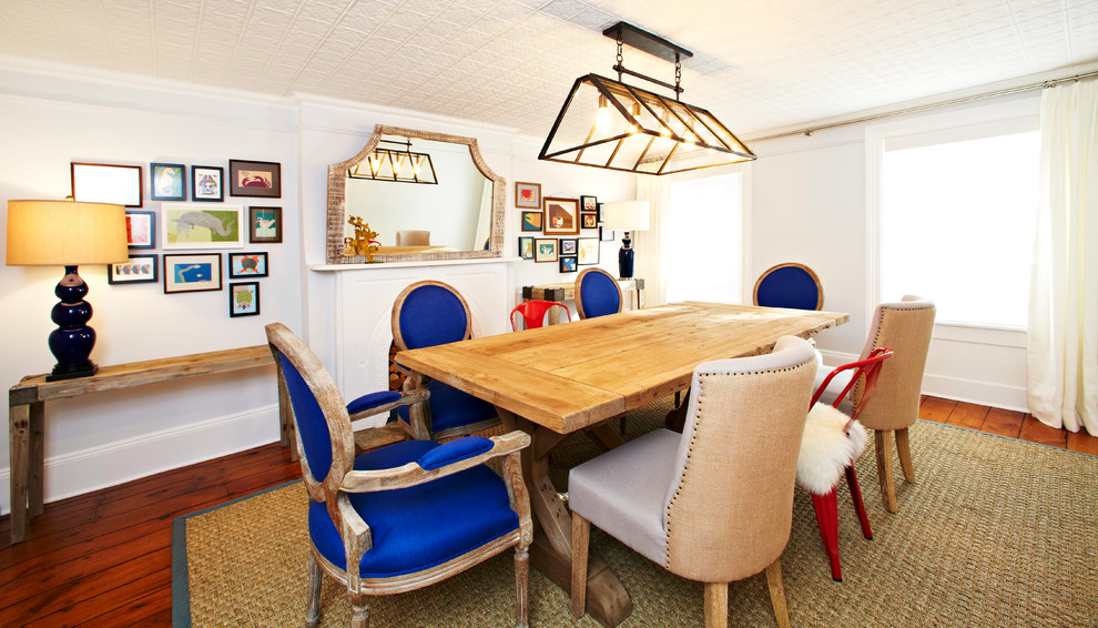 Aménagement d'une grande rideau de salle à manger éclectique fermée avec un mur bleu, un sol en bois brun, une cheminée standard et un manteau de cheminée en pierre.