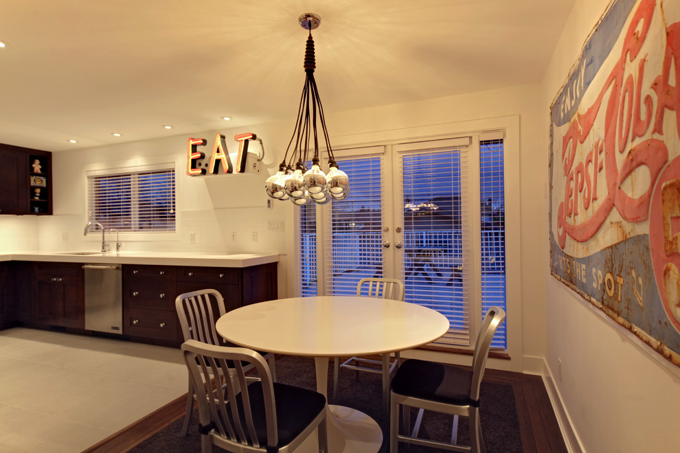 Idée de décoration pour une salle à manger ouverte sur la cuisine bohème avec un mur blanc et parquet foncé.