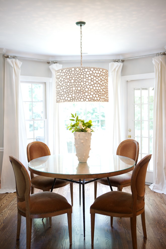 Modelo de comedor tradicional con paredes grises, suelo de madera oscura y cortinas