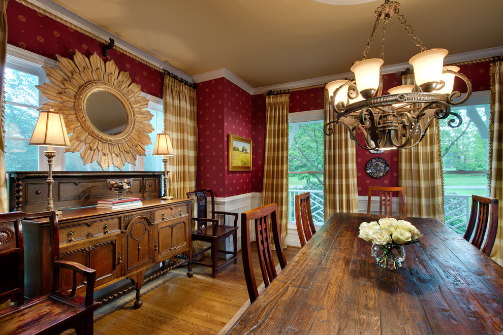 На фото: кухня-столовая в классическом стиле с красными стенами и коричневым полом с