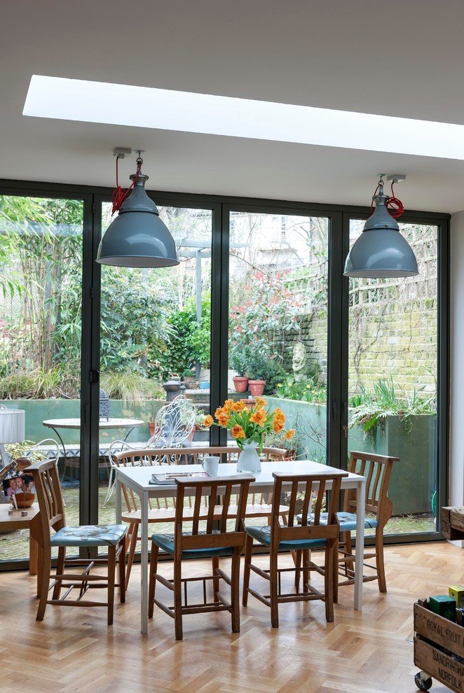 Inspiration for a medium sized bohemian open plan dining room in London with medium hardwood flooring.