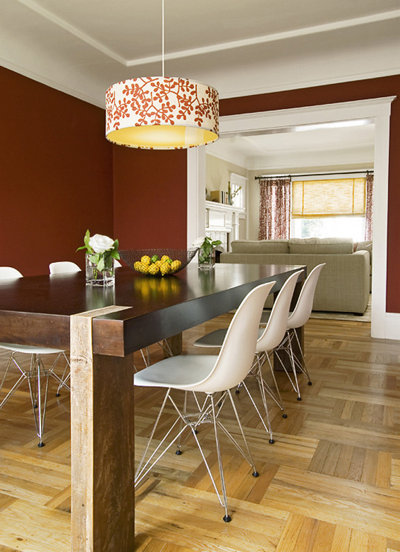 Réalisation d'une salle à manger bohème fermée et de taille moyenne avec un mur rouge et parquet clair.