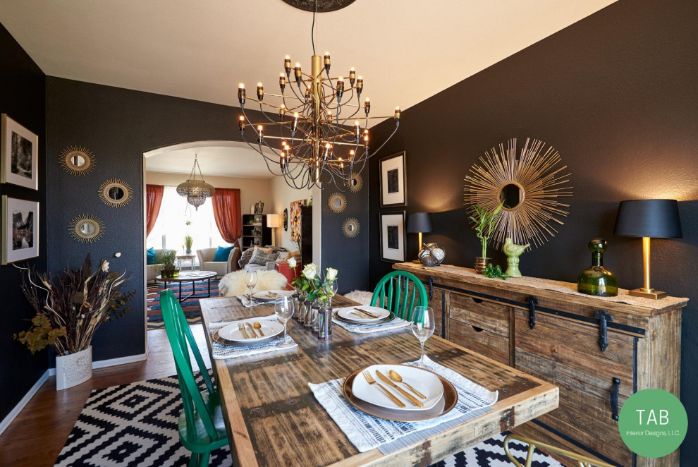 Aménagement d'une petite salle à manger ouverte sur la cuisine éclectique avec un mur noir, un sol en bois brun, aucune cheminée et un sol marron.