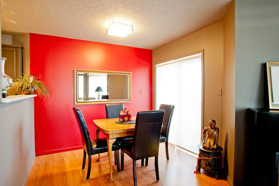 Idées déco pour une salle à manger ouverte sur la cuisine éclectique de taille moyenne avec un mur rouge et un sol en bois brun.