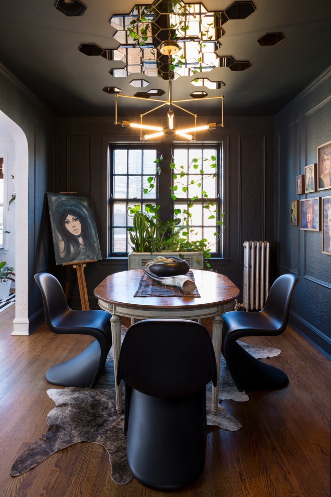 Design ideas for an eclectic enclosed dining room in Chicago with black walls and dark hardwood flooring.