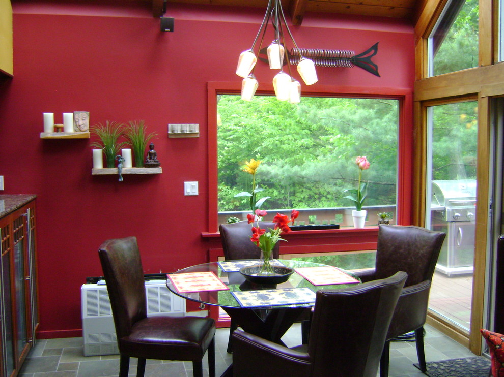 Cette image montre une salle à manger ouverte sur la cuisine bohème de taille moyenne avec un mur rouge et un sol en carrelage de céramique.