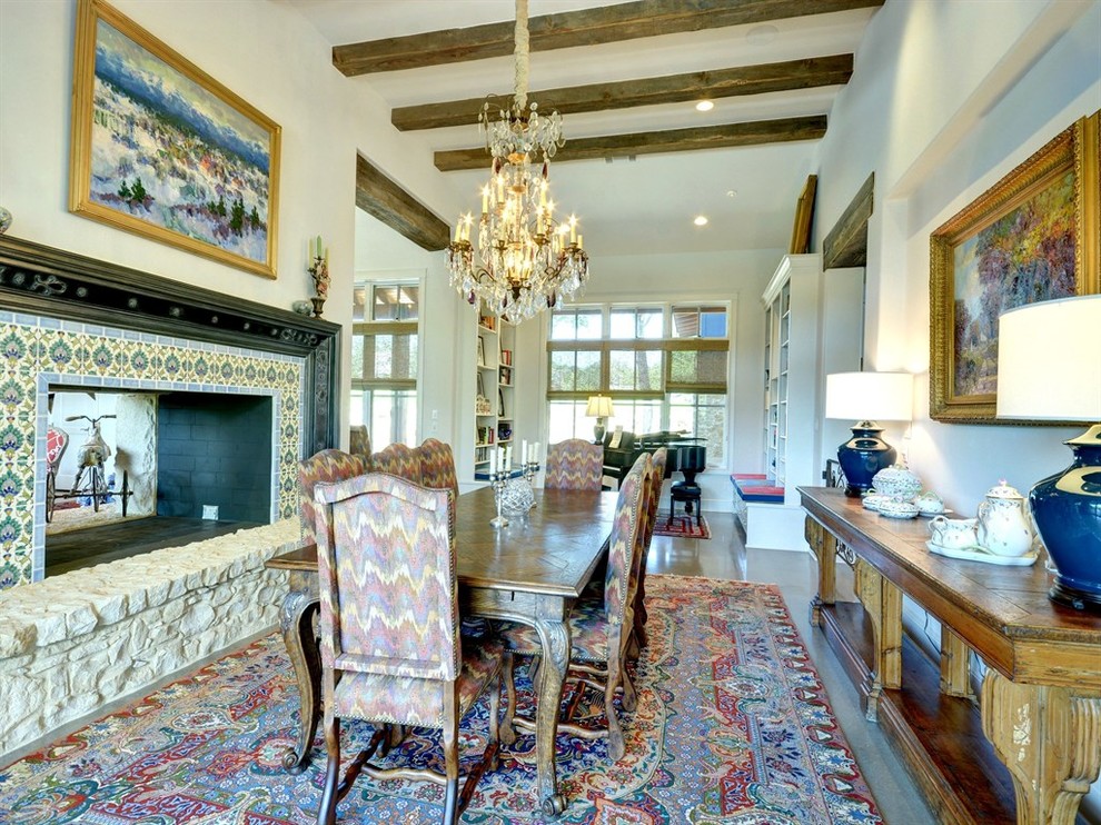 Inspiration pour une grande salle à manger ouverte sur le salon bohème avec un mur blanc, sol en béton ciré, une cheminée double-face, un sol beige et un manteau de cheminée en carrelage.