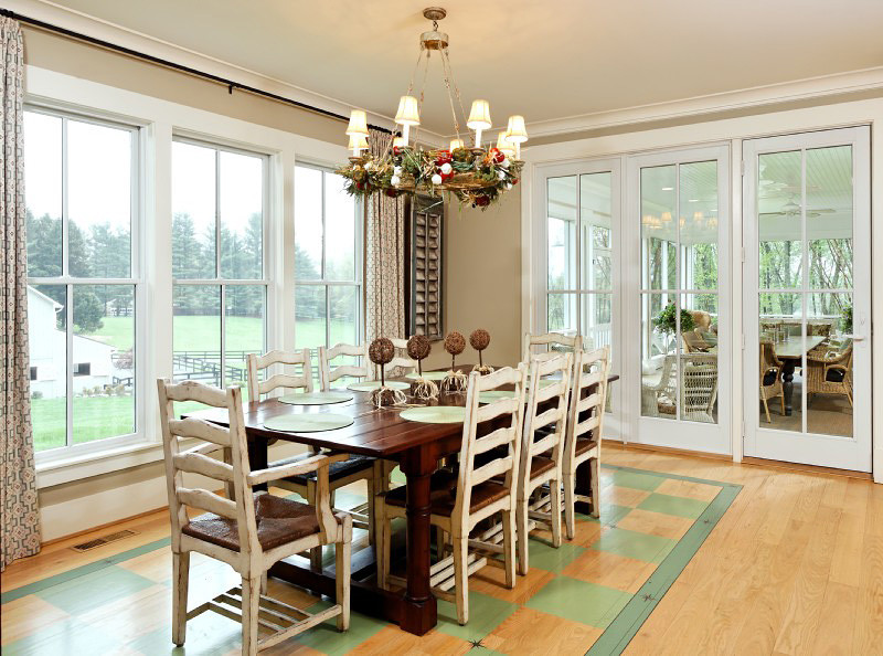 Immagine di una sala da pranzo aperta verso la cucina tradizionale con pareti beige, parquet chiaro e pavimento verde