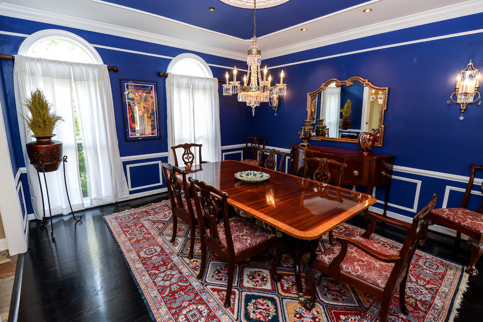 На фото: отдельная столовая в классическом стиле с синими стенами и темным паркетным полом