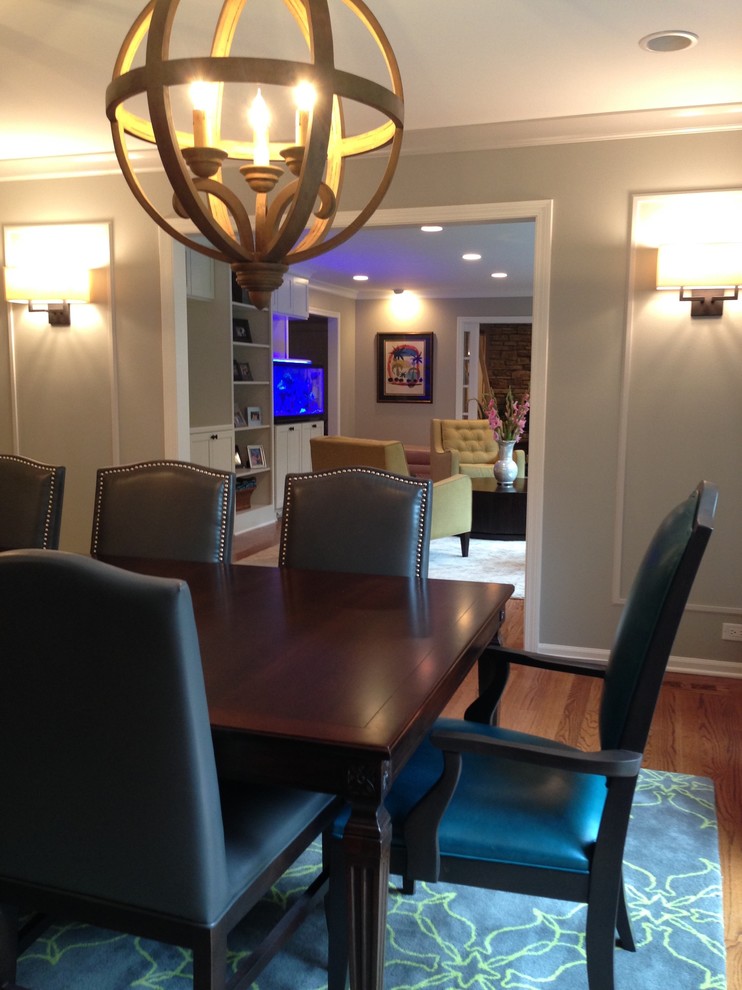 Example of a mid-sized eclectic medium tone wood floor enclosed dining room design in Other with gray walls and no fireplace