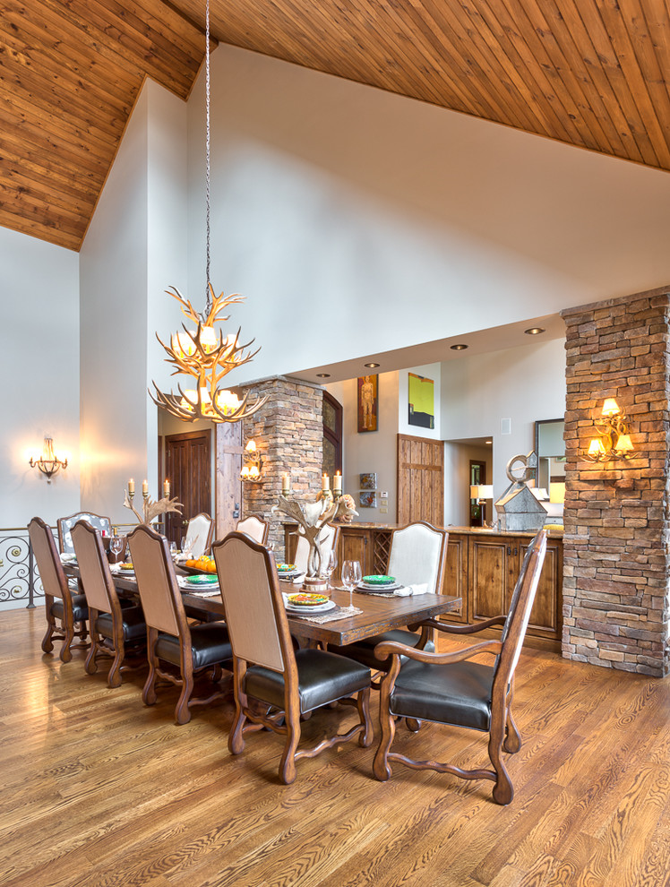 Réalisation d'une salle à manger ouverte sur la cuisine chalet de taille moyenne avec un mur blanc et un sol en bois brun.