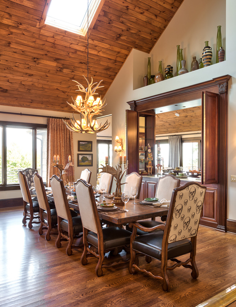Idée de décoration pour une salle à manger ouverte sur le salon chalet de taille moyenne avec un mur blanc et un sol en bois brun.