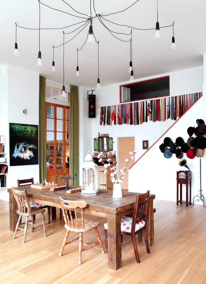 Inspiration for a large eclectic light wood floor dining room remodel in London with white walls and no fireplace