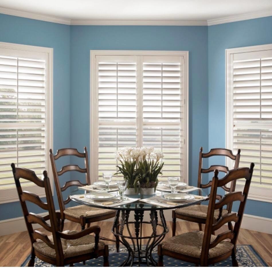 Immagine di una sala da pranzo aperta verso il soggiorno tradizionale di medie dimensioni con pareti blu, pavimento in legno massello medio e nessun camino