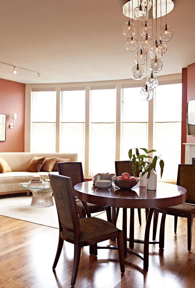Example of a small trendy medium tone wood floor enclosed dining room design in San Francisco with red walls