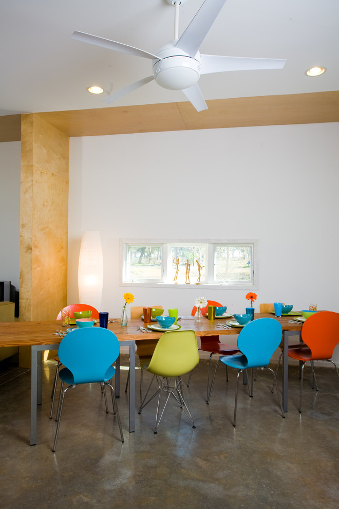 Ispirazione per una sala da pranzo contemporanea con pareti bianche, pavimento in cemento e nessun camino