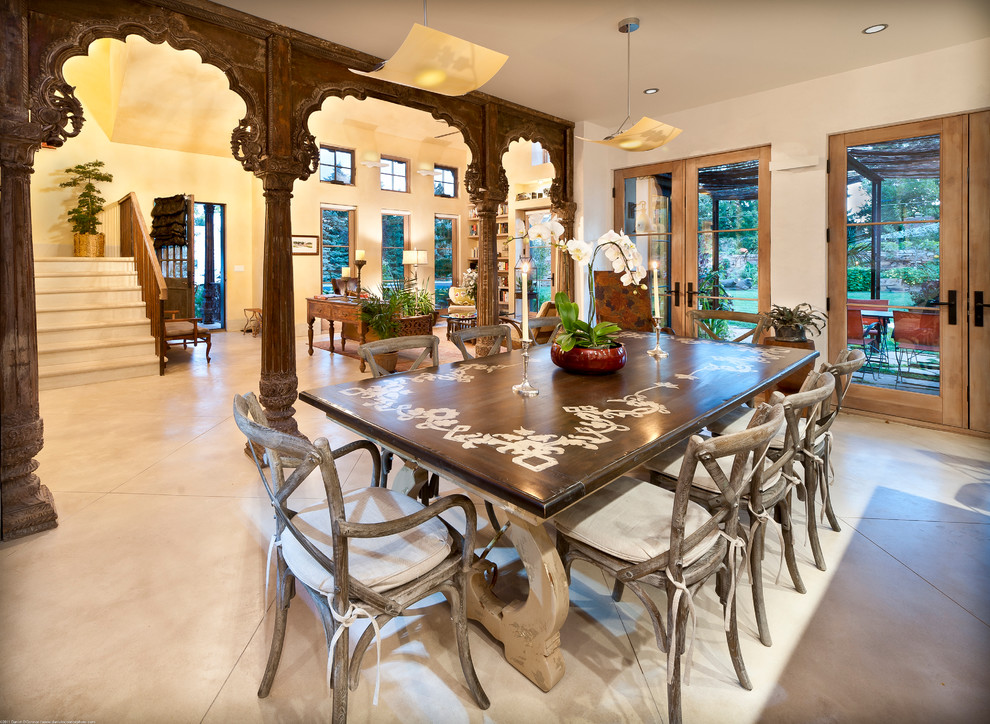 Immagine di una sala da pranzo aperta verso il soggiorno mediterranea con pareti beige