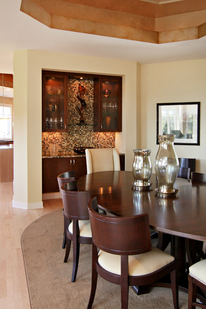 Cette image montre une salle à manger traditionnelle avec un mur beige et parquet clair.
