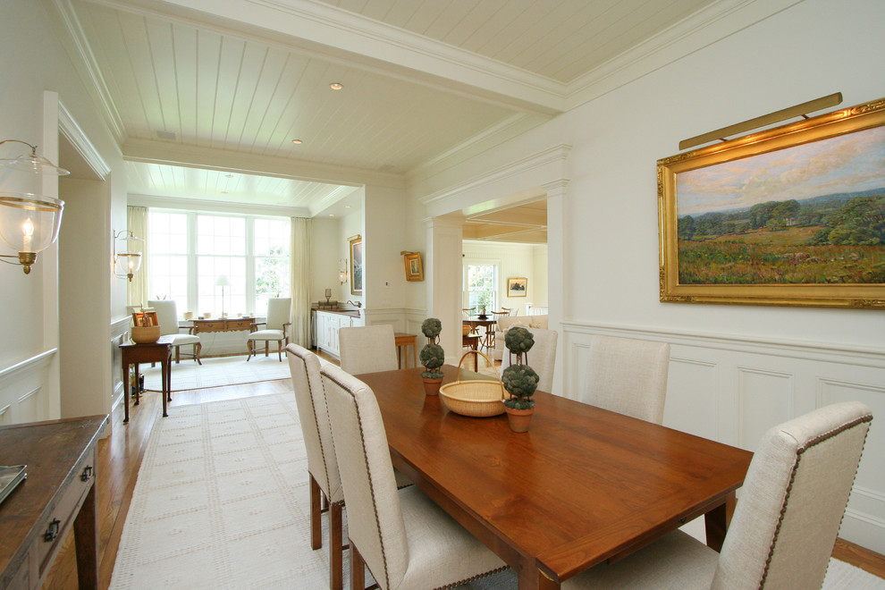 Mid-sized beach style medium tone wood floor enclosed dining room photo in Boston with white walls