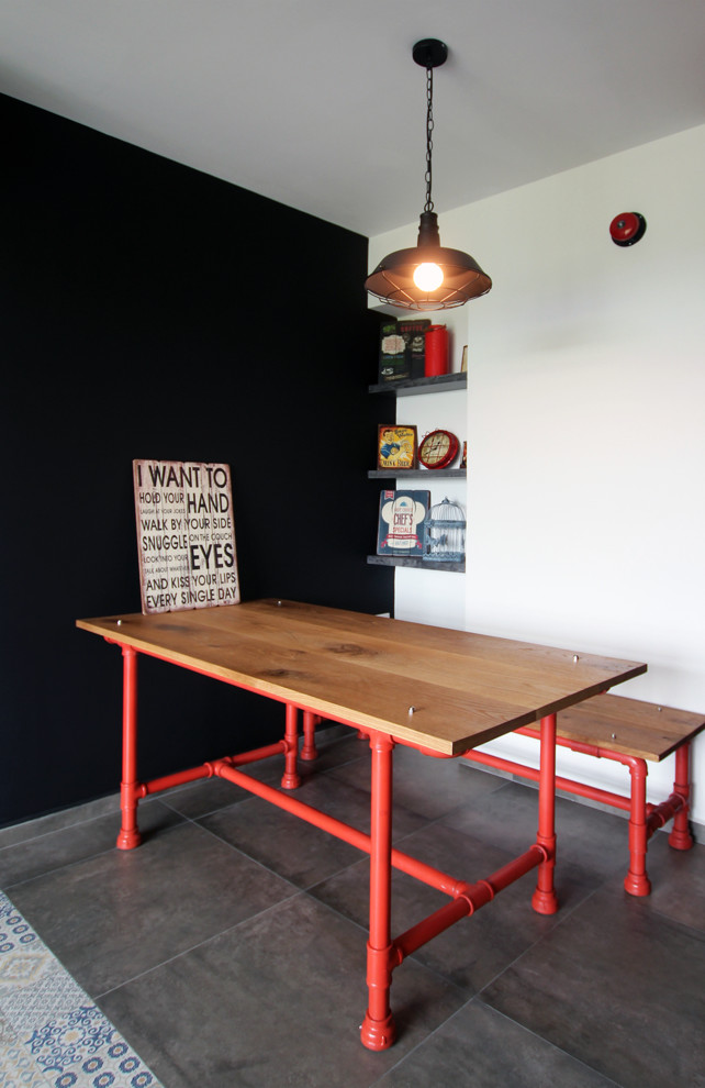 This is an example of an industrial dining room in Singapore with black walls.