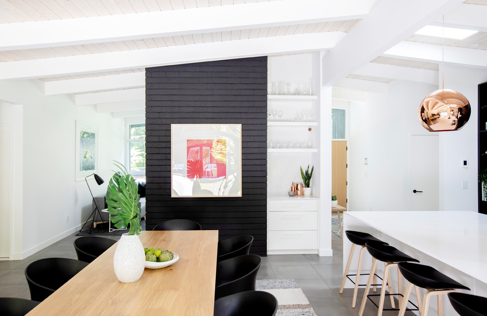 Exemple d'une grande salle à manger ouverte sur la cuisine rétro avec un mur blanc, un sol gris, sol en béton ciré et aucune cheminée.