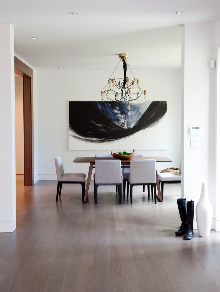 Esempio di una sala da pranzo aperta verso il soggiorno contemporanea con pareti bianche e pavimento in legno massello medio